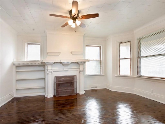 unfurnished living room featuring dark hardwood / wood-style floors, plenty of natural light, ceiling fan, and crown molding