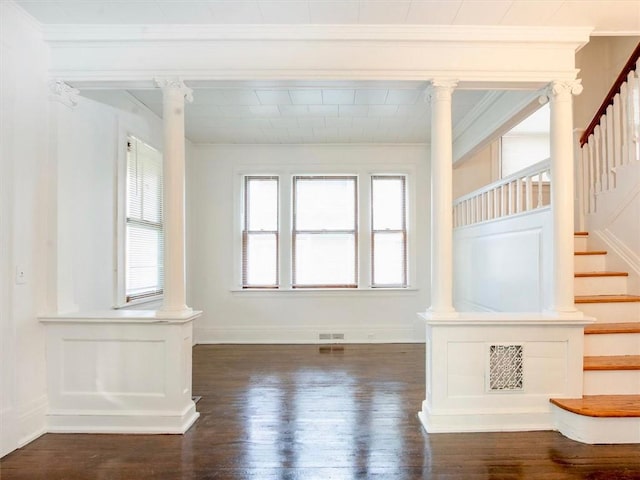 interior space featuring dark hardwood / wood-style floors, ornate columns, and crown molding