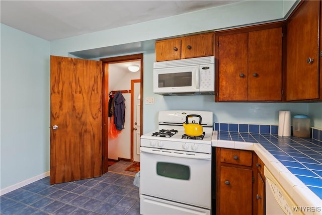 kitchen featuring white appliances and tile countertops