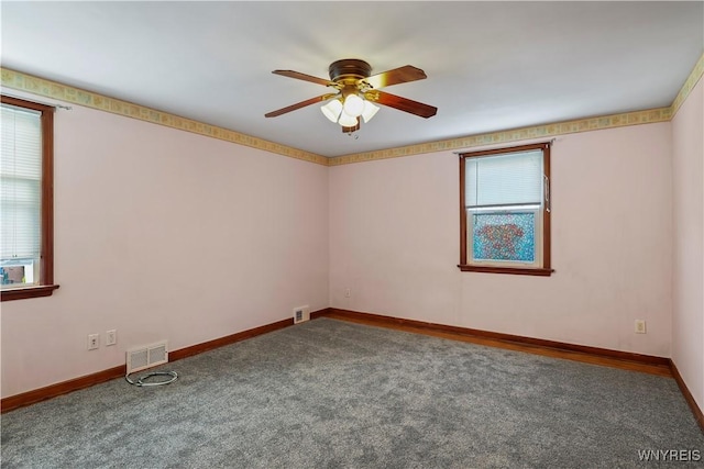 empty room with carpet flooring, ceiling fan, and plenty of natural light