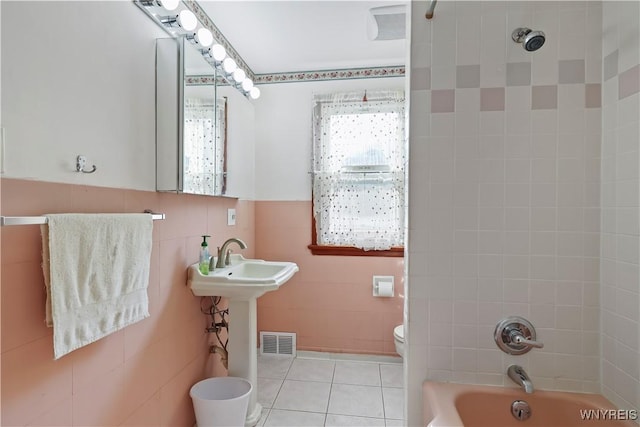 bathroom featuring tiled shower / bath combo and toilet