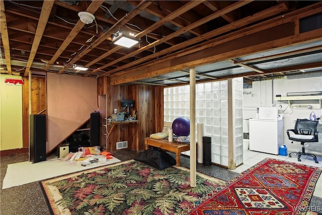 basement with washer / clothes dryer and wood walls