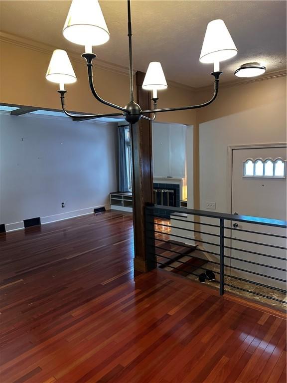 basement with a fireplace, dark hardwood / wood-style flooring, and crown molding