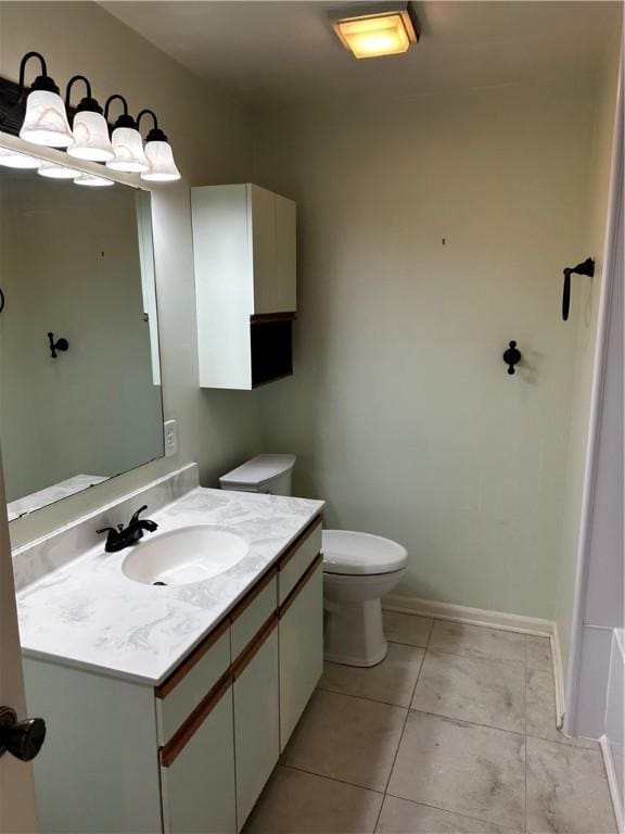 bathroom with tile patterned floors, a tub, vanity, and toilet