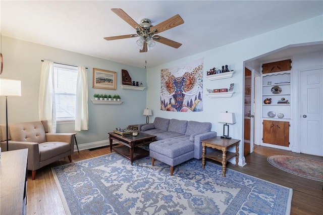 living room with ceiling fan and dark hardwood / wood-style flooring