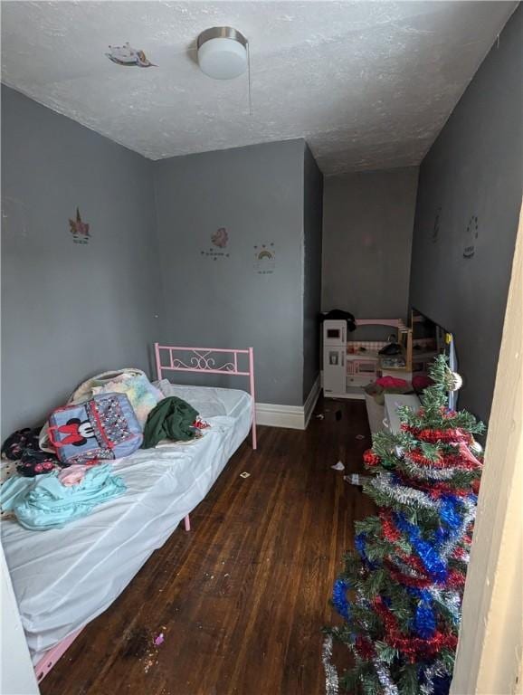 bedroom with dark hardwood / wood-style flooring and a textured ceiling