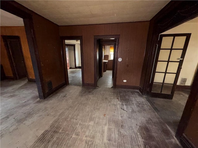 unfurnished room with hardwood / wood-style floors and wooden walls