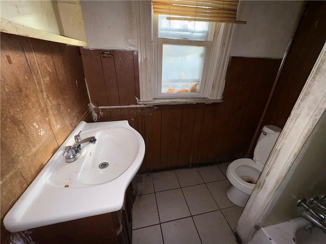 bathroom featuring tile patterned floors, vanity, toilet, and wooden walls