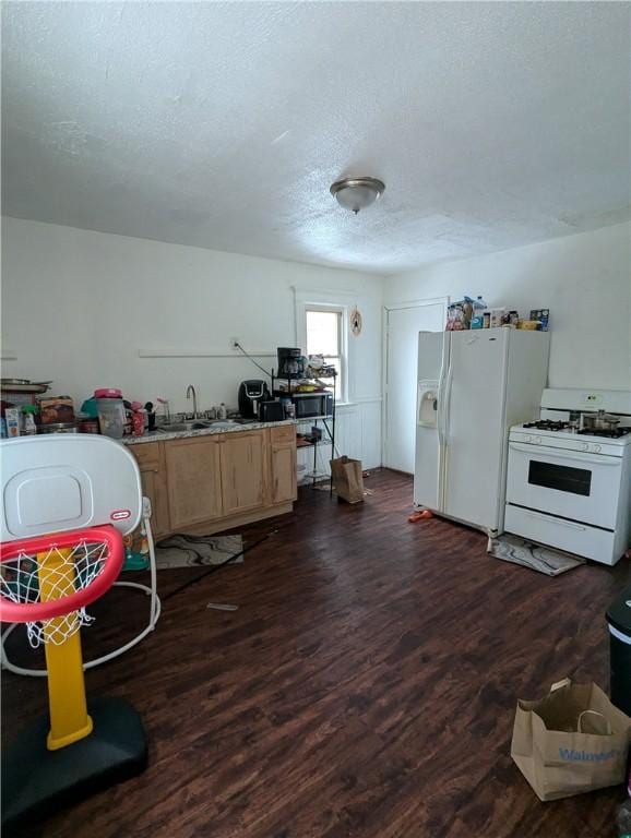 kitchen featuring a textured ceiling, sink, dark wood-type flooring, and white appliances