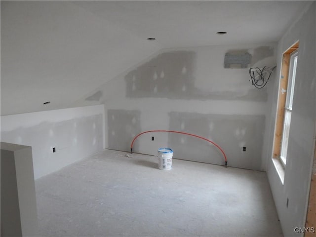 unfurnished room with vaulted ceiling