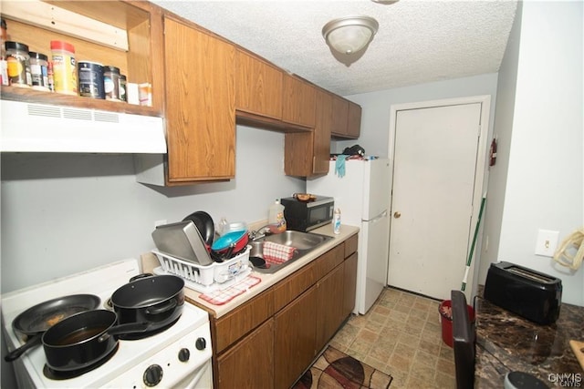 kitchen featuring sink, white appliances, a textured ceiling, and exhaust hood