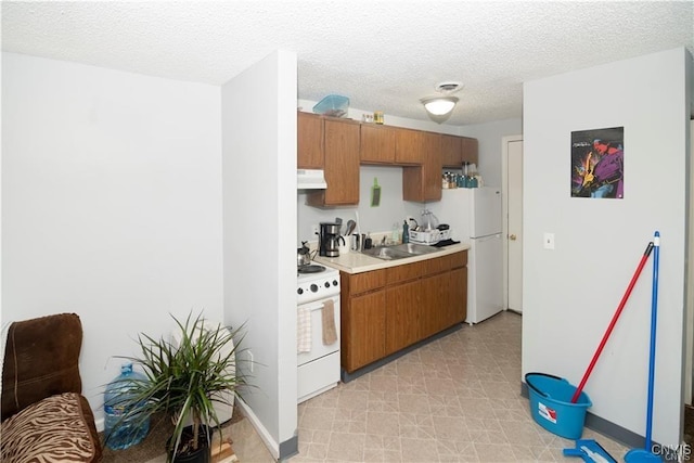 kitchen with white appliances and a textured ceiling