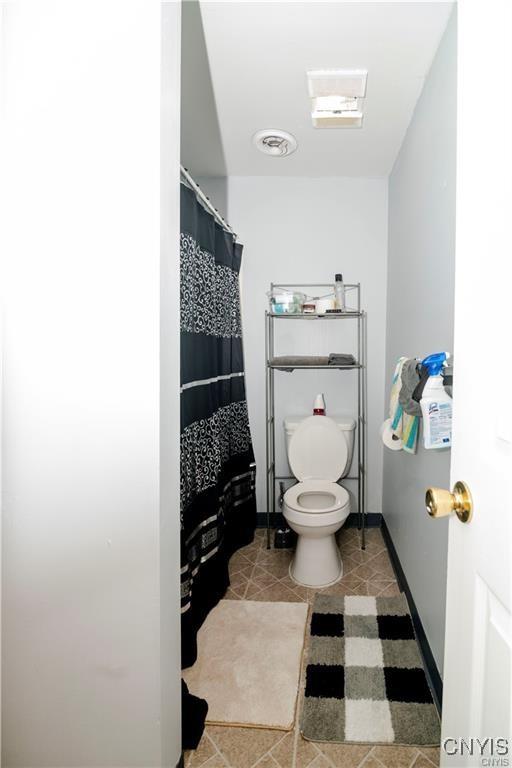 bathroom with tile patterned floors, toilet, and walk in shower