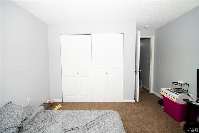 bedroom featuring carpet flooring, a textured ceiling, and a closet