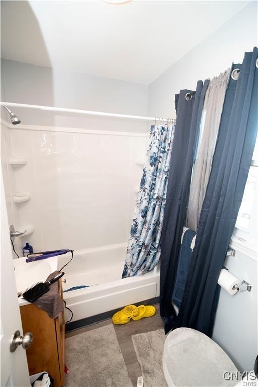 bathroom featuring shower / bath combo and toilet