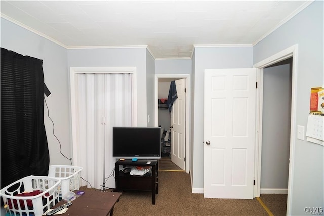 bedroom with dark colored carpet, ornamental molding, and a closet