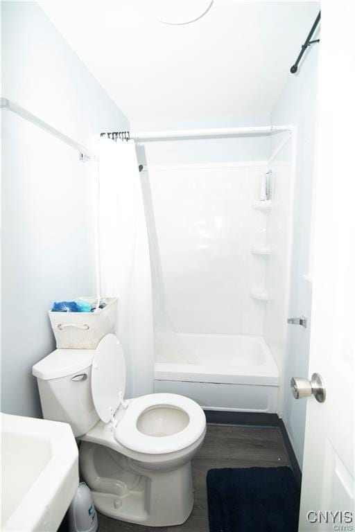 full bathroom featuring washtub / shower combination, toilet, wood-type flooring, and sink