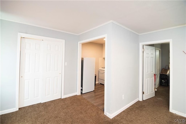 unfurnished bedroom featuring carpet, white fridge, a closet, and crown molding