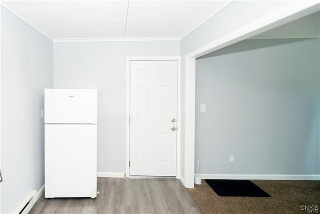 interior space featuring light hardwood / wood-style floors, white refrigerator, ornamental molding, and a baseboard heating unit