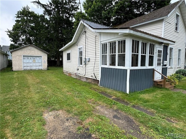 view of side of home with a yard, an outbuilding, and a garage