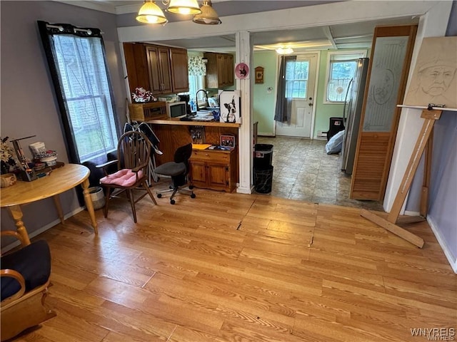 home office featuring a notable chandelier, crown molding, and light hardwood / wood-style flooring