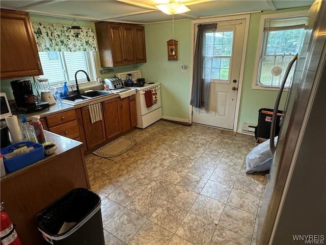 kitchen featuring hanging light fixtures, white range with electric stovetop, baseboard heating, and sink