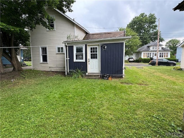 rear view of property featuring a lawn