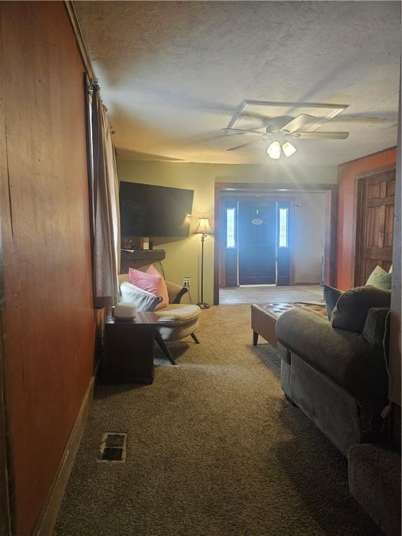 carpeted bedroom with ceiling fan and a textured ceiling