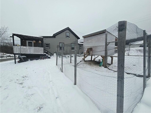 view of snow covered back of property