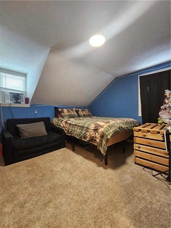 carpeted bedroom with cooling unit and lofted ceiling