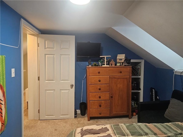 bedroom with light colored carpet and vaulted ceiling