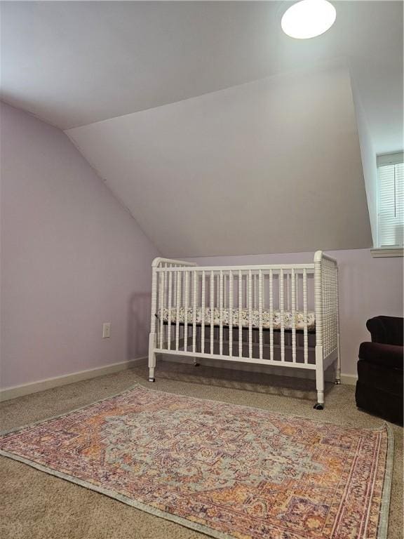 bedroom with carpet flooring, vaulted ceiling, and a nursery area