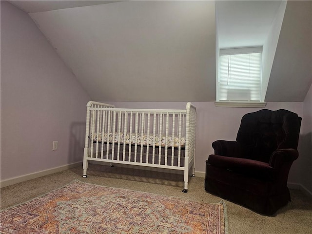 carpeted bedroom featuring a crib and lofted ceiling