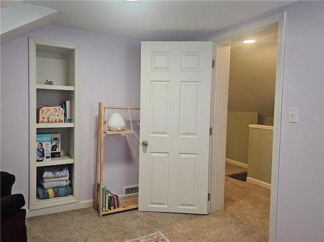 interior space with built in shelves and light colored carpet