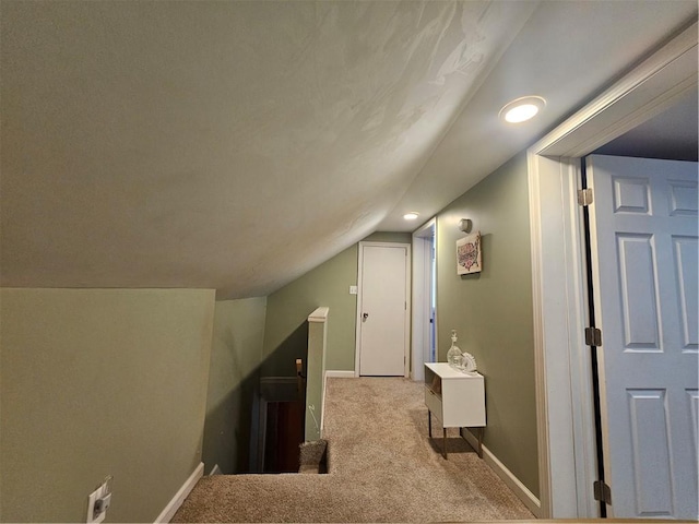 bonus room with light carpet and vaulted ceiling