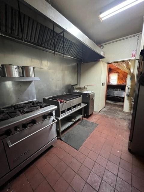 kitchen with stainless steel stove and tile patterned floors