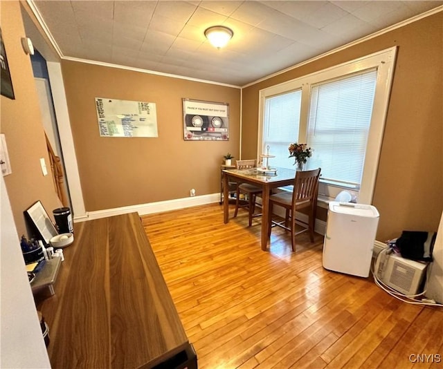 dining space featuring crown molding and light wood-type flooring