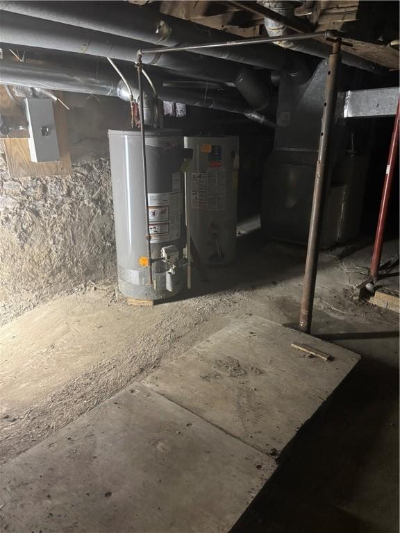 basement with gas water heater, electric panel, and water heater