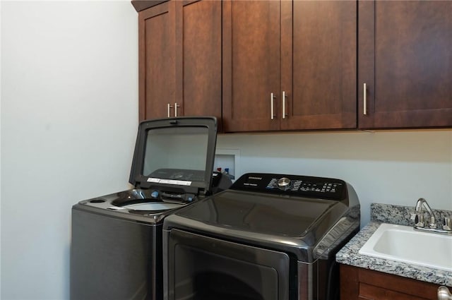 laundry area featuring cabinets, sink, and washing machine and clothes dryer