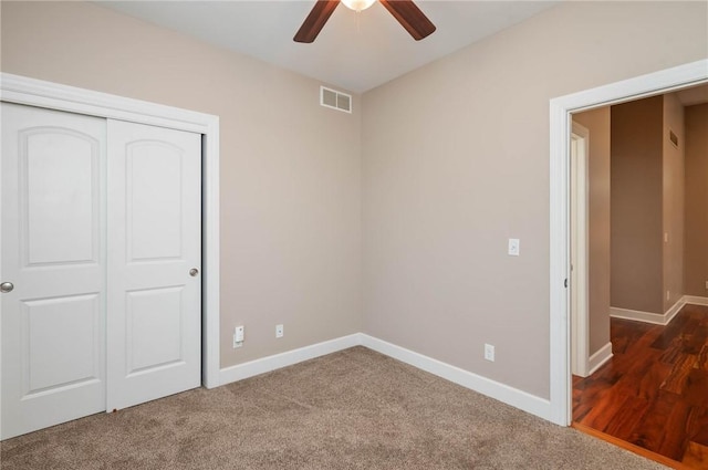 unfurnished bedroom featuring ceiling fan, dark carpet, and a closet