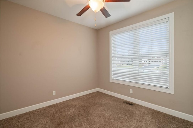 carpeted empty room featuring ceiling fan and plenty of natural light