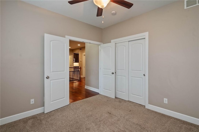 unfurnished bedroom featuring carpet, ceiling fan, and a closet