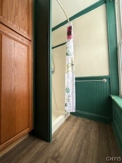 bathroom featuring hardwood / wood-style floors, a shower, and radiator