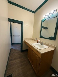 bathroom with vanity, hardwood / wood-style flooring, and crown molding