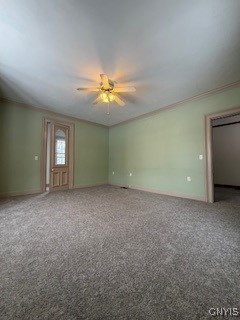 empty room featuring carpet flooring, ceiling fan, and crown molding