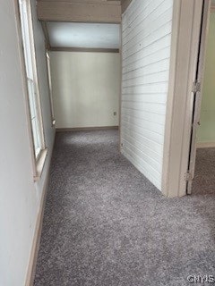 hall with dark colored carpet