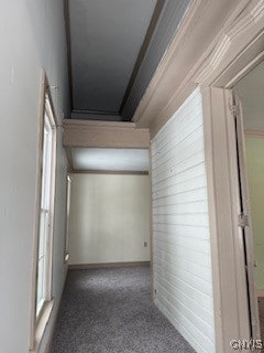 corridor featuring crown molding and dark colored carpet