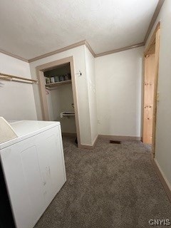 clothes washing area with dark colored carpet, ornamental molding, and washer / dryer