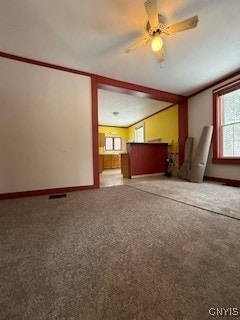 unfurnished living room with carpet flooring, ceiling fan, and a wealth of natural light