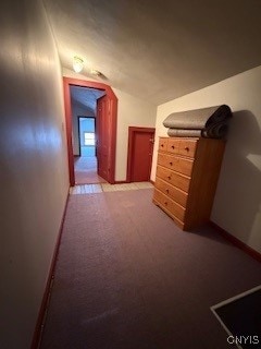 hallway featuring light colored carpet and vaulted ceiling